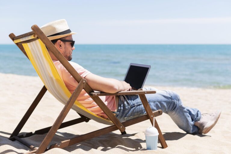 man met laptop in strandstoel