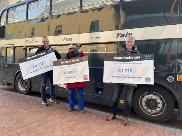 cheques eindejaarsactie goede doelen 2021 drie medewerkers New Nexus voor de Buster met cheque voor goed doel