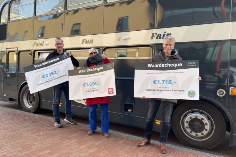 drie medewerkers New Nexus voor de Buster met cheque voor goed doel