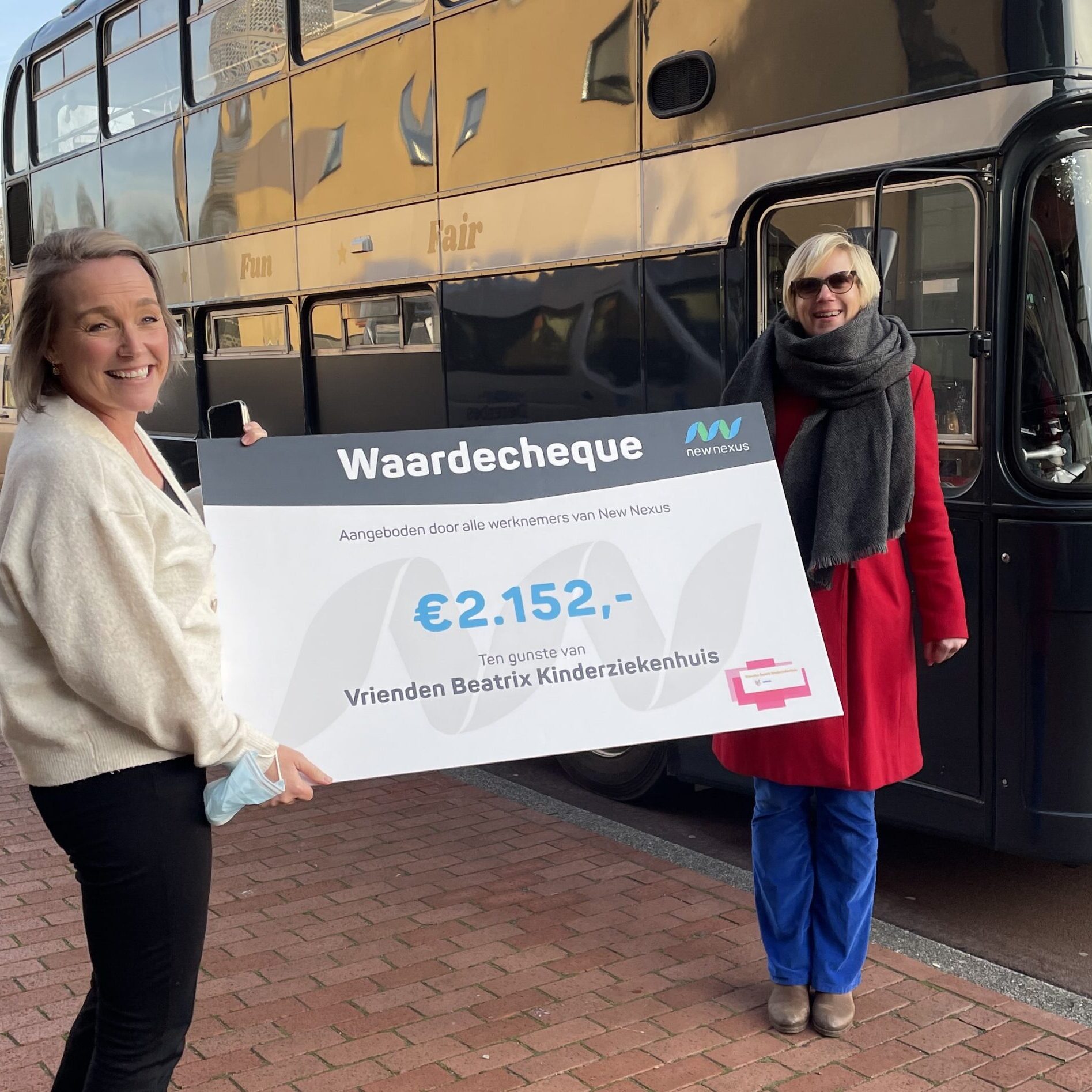 overhandiging cheque door New Nexus medewerker aan Vrienden Beatrix Kinderziekenhuis