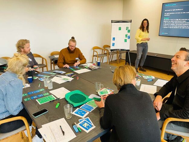Een team van personen die de workshop Agile Game volgen bij New Nexus