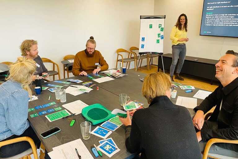 Een team van personen die de workshop Agile Game volgen bij New Nexus