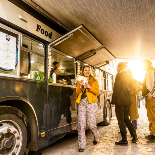 Hongerige deelnemers van een festival in de rij bij Buster Foodtruck voor een lekkernij