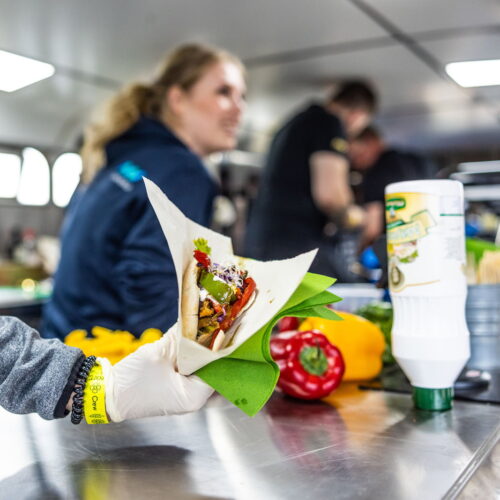 Een lekkernij wordt overhandigd aan een hongerige deelnemer