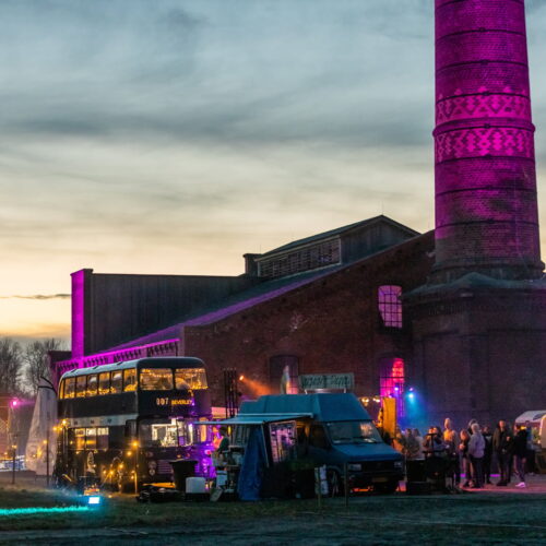 Buster Foodtruck tijdens een sfeervolle festival omgeven door neon verlichting