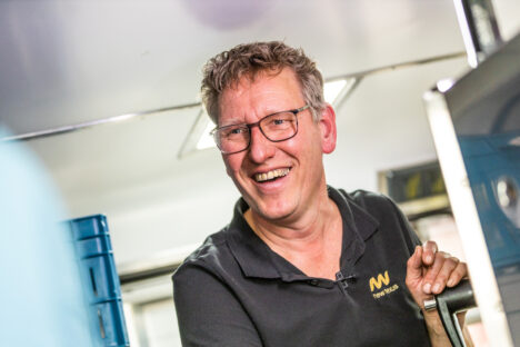 Harrie, de manager van Buster Foodtruck poseert met een brede lach