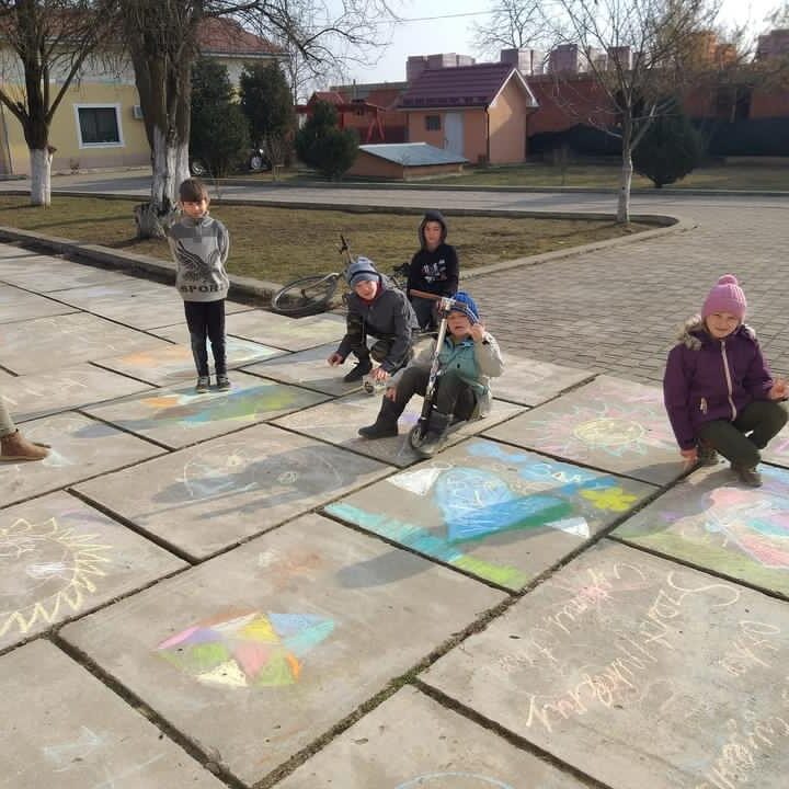 Kinderen maken stoepkrijttekeningen om vluchtelingen zich welkom te laten voelen