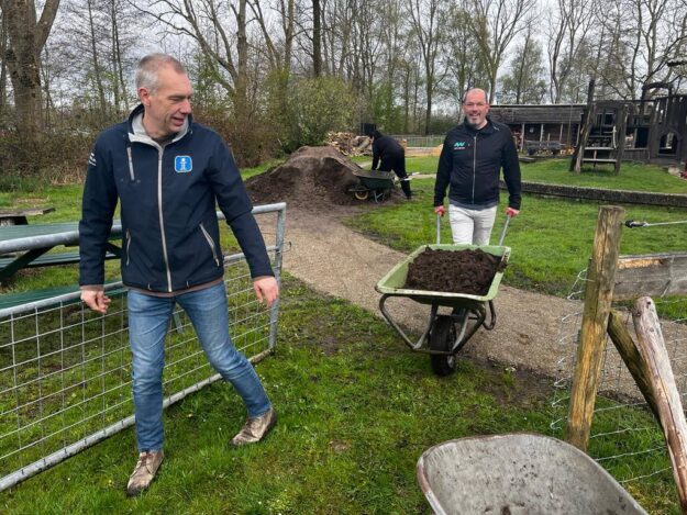 Twee medewerkers van New Nexus helpen met zand verplaatsen tijdens de New Nexus vrijwilligersdag Twee medewerkers van New Nexus helpen met zand verplaatsen tijdens de New Nexus vrijwilligersdag