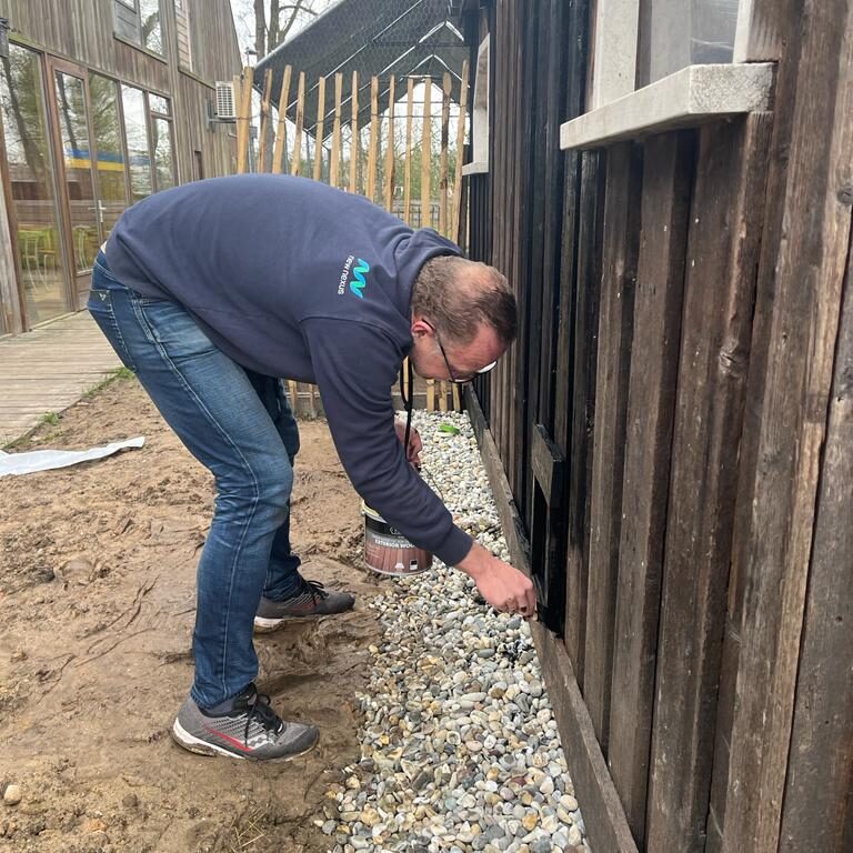 Collega beitst kippenhok tijdens vrijwilligersdag