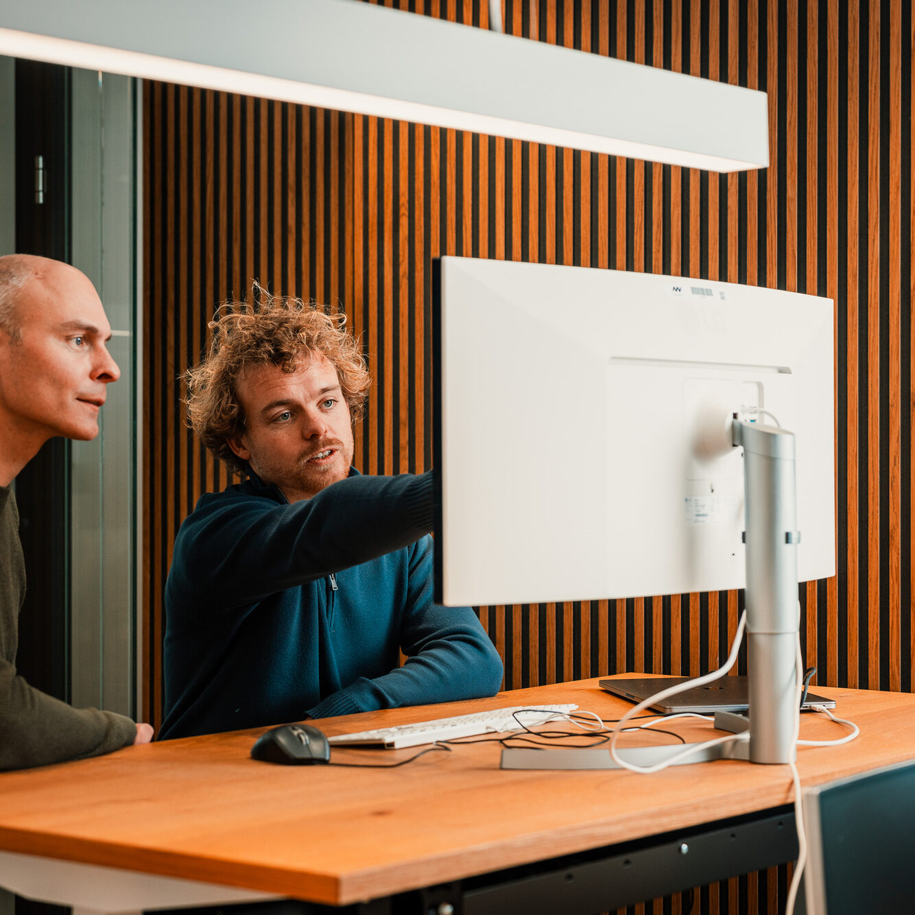 Richard Gerrits en developer Fabian samen in gesprek achter een beeldscherm bij New Nexus