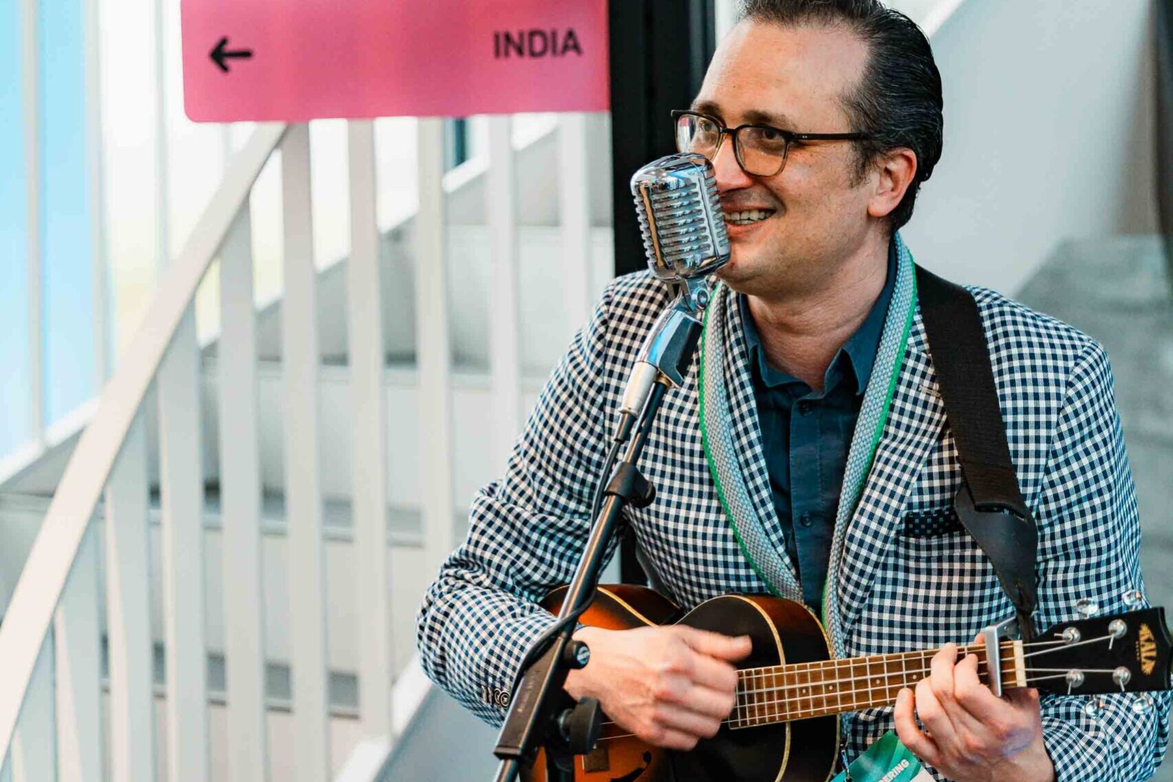 Troubadour speelt gitaar onder de gekleurde bewegwijzering naar alle activiteiten bij het event Voor de Verandering