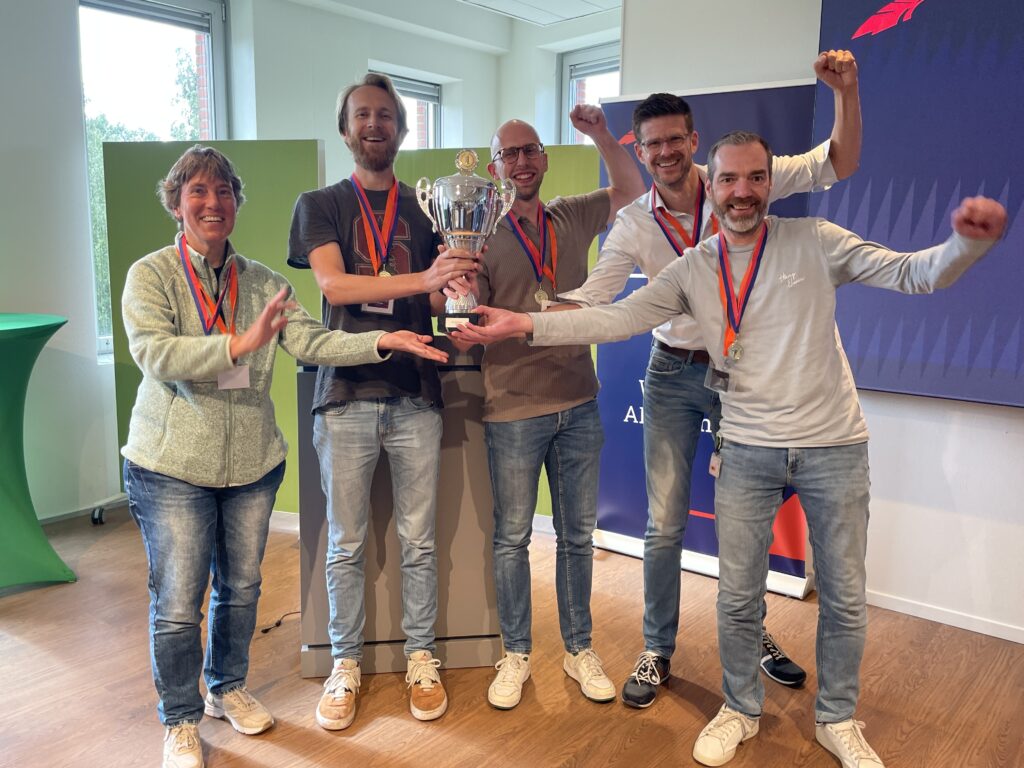 De vijf leden van het winnende team VIN-IT houden samen de beker vast als RDW AI Champion