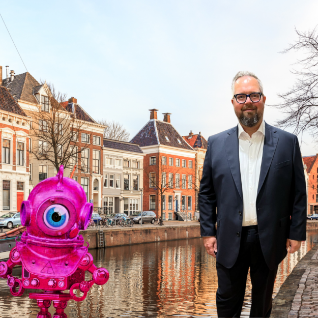 Spreker op aiGrunn Marco Tenback staat samen met roze robot op de kade van de Westerhaven