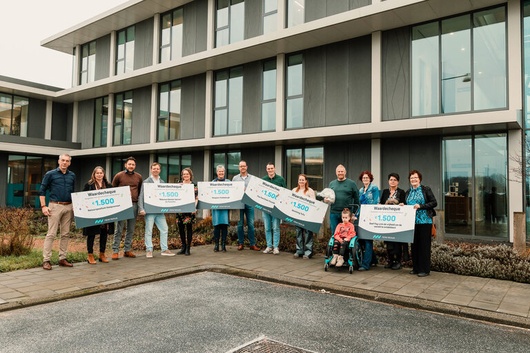 Alle goede doelen met cheque op een rij voor kantoor New Nexus