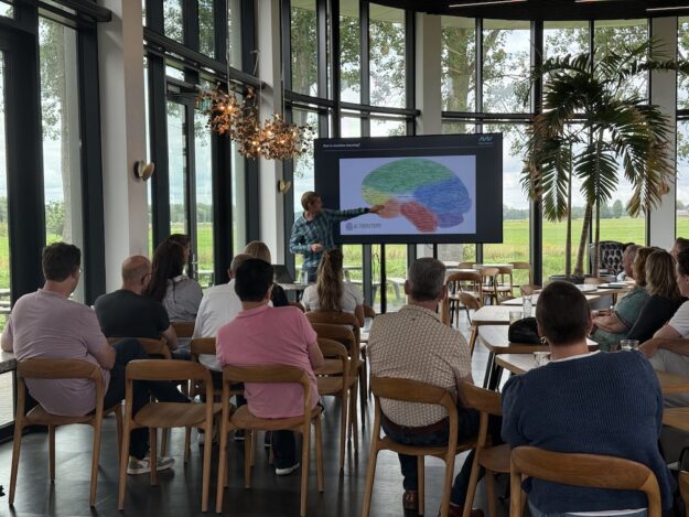 Oscar Koster wijst presenteert slide hersengebieden in zijn training voorspellende data tijdens de AI Summer School bij New Nexus