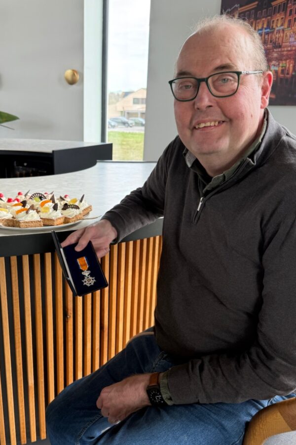 Bernhard Hoekstra met lintje bij New Nexus Bernhard Hoekstra met lintje en oranjekoek aan de bar bij New Nexus