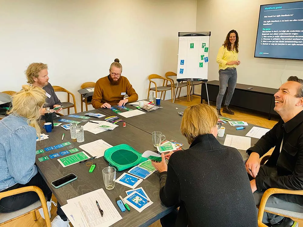 Een team van personen die de workshop Agile Game volgen bij New Nexus